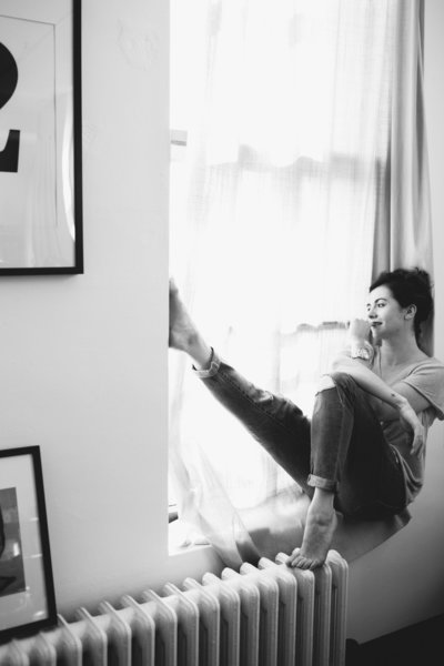 Woman  sitting in a windowsill with her feet kicked up