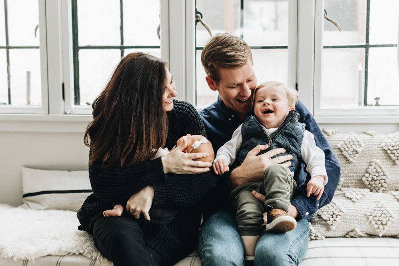 Man and Woman holding a toddler and a newbord