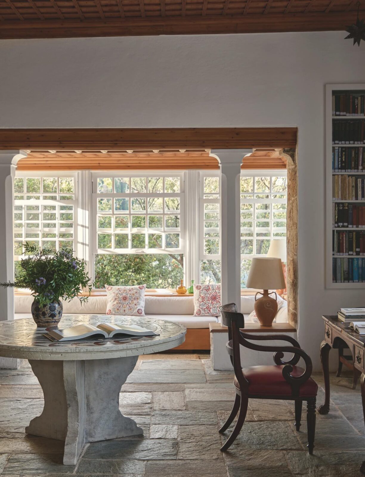 dining room with textured stone flooring, wood ceilings, and windows overlooking the garden