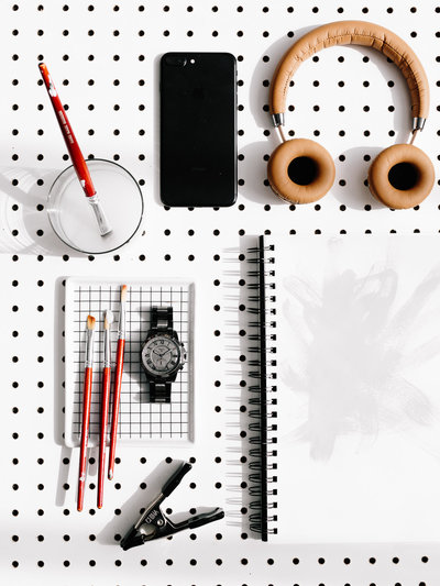 Laydown image of notebooks, watch, phone, headphones