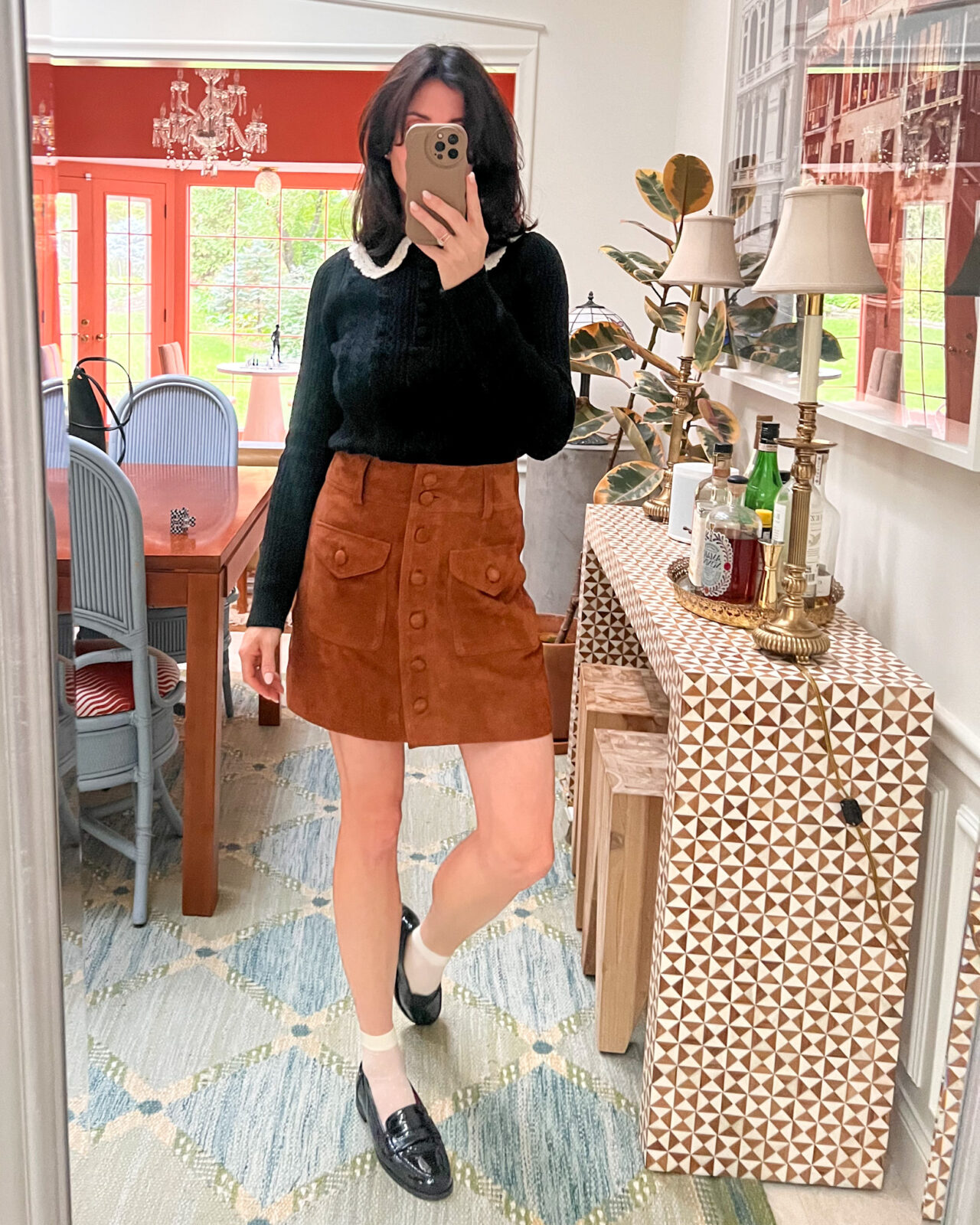 Mirror selfie featuring a black sweater with a Peter Pan collar, brown skirt, and loafers.